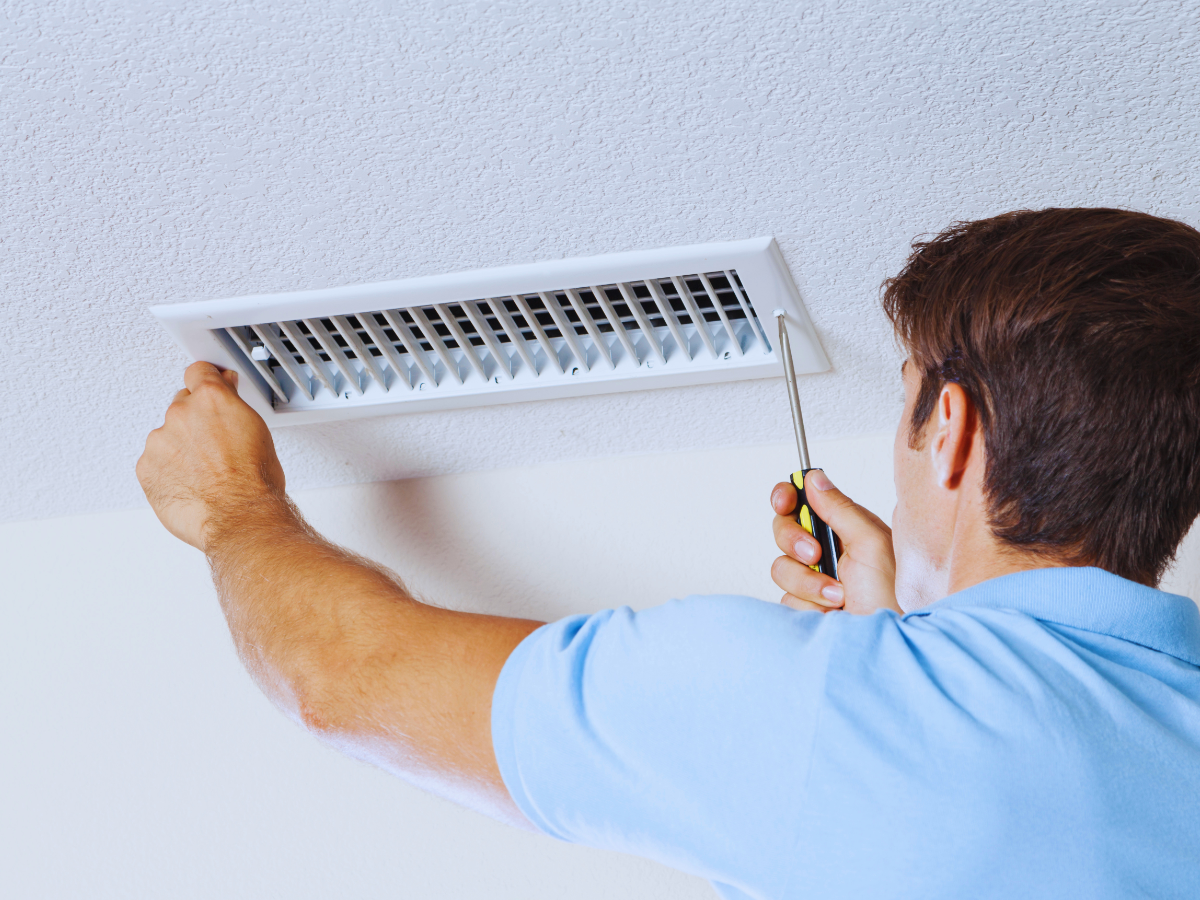 HVAC tech inspecting air duct that is leaking air